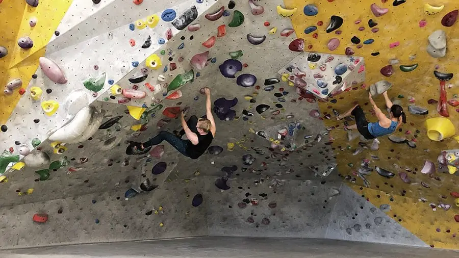 two women climbers bouldering